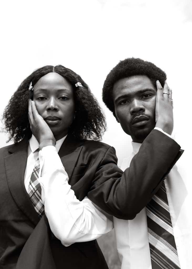 Elegant black and white portrait of two business professionals in suits showcasing unity and style.